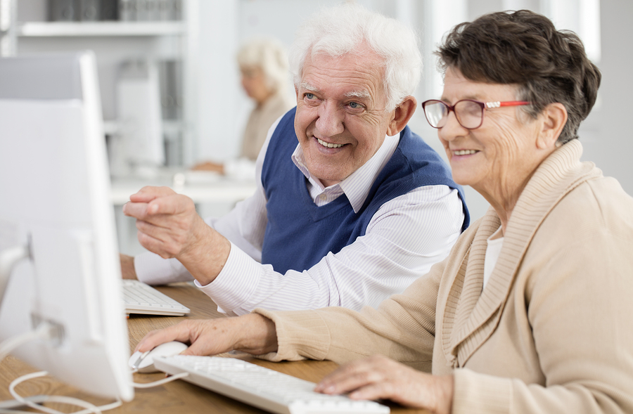 Senior woman smiling while using a laptop at home